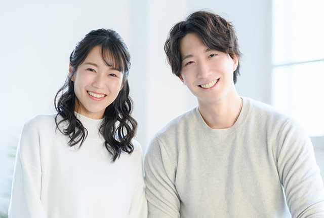 若いカップルが横に並び微笑む様子